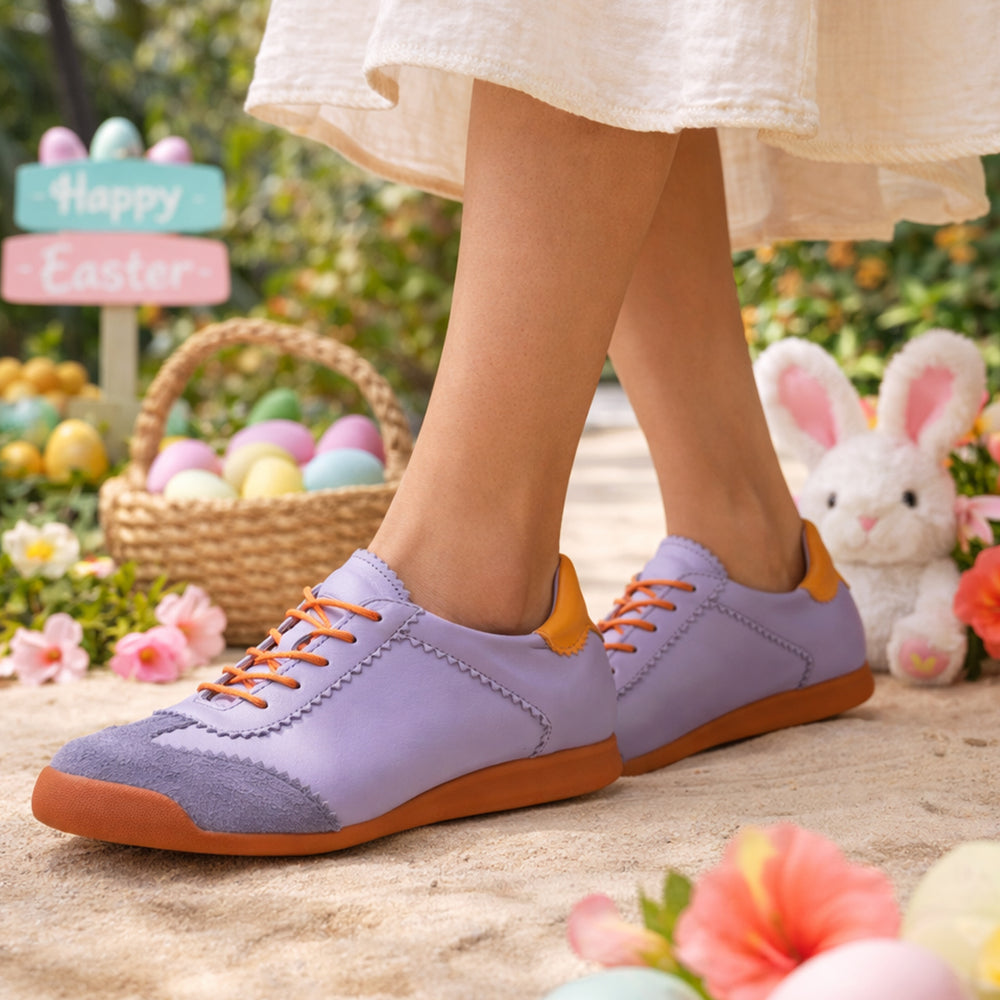 Purple sneakers with orange soles worn by a person, with Easter decorations in the background.