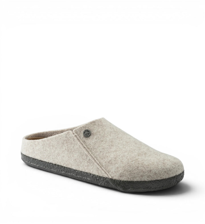 Birkenstock Zermatt wool felt mule slippers in eggshell with a dark grey sole and decorative button detail.