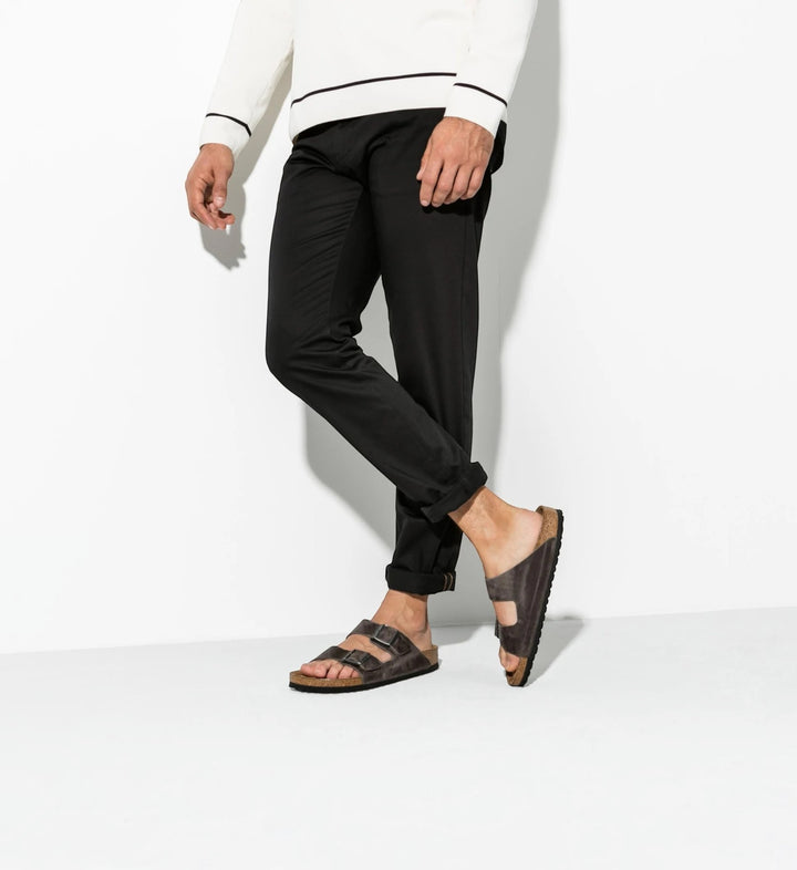 House of Florian Arizona oiled leather sandals in iron grey with soft footbed, worn by a man in black trousers.