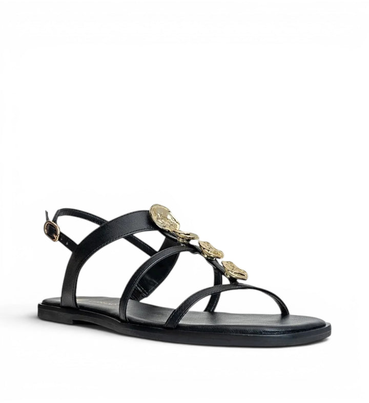 House of Florian black leather flat sandals with gold coin embellishments and ankle strap.