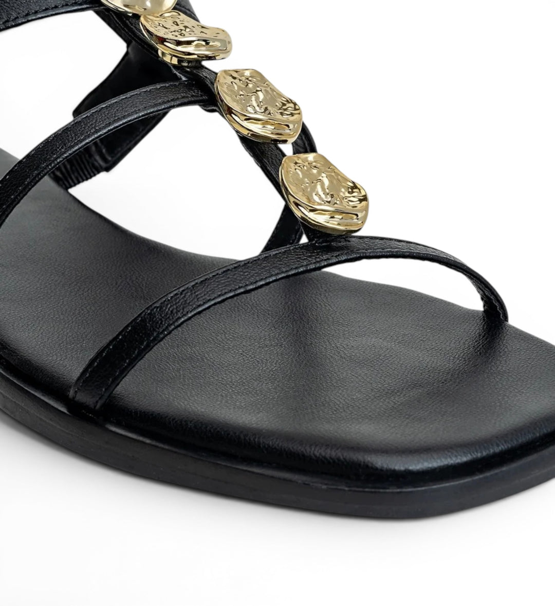 House of Florian black leather flat sandals with gold-tone hammered disc embellishments and thin straps.