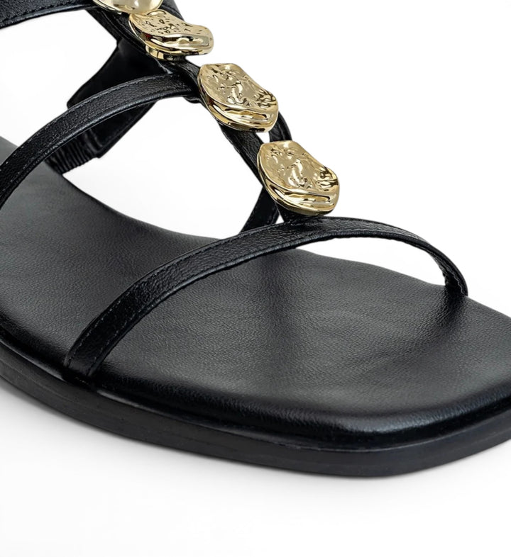 House of Florian black leather flat sandals with gold-tone hammered disc embellishments and thin straps.