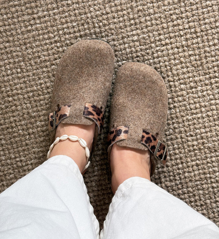 House of Florian Dr Feet  honey camel felt clogs with leopard print strap detail worn with white trousers and shell anklet