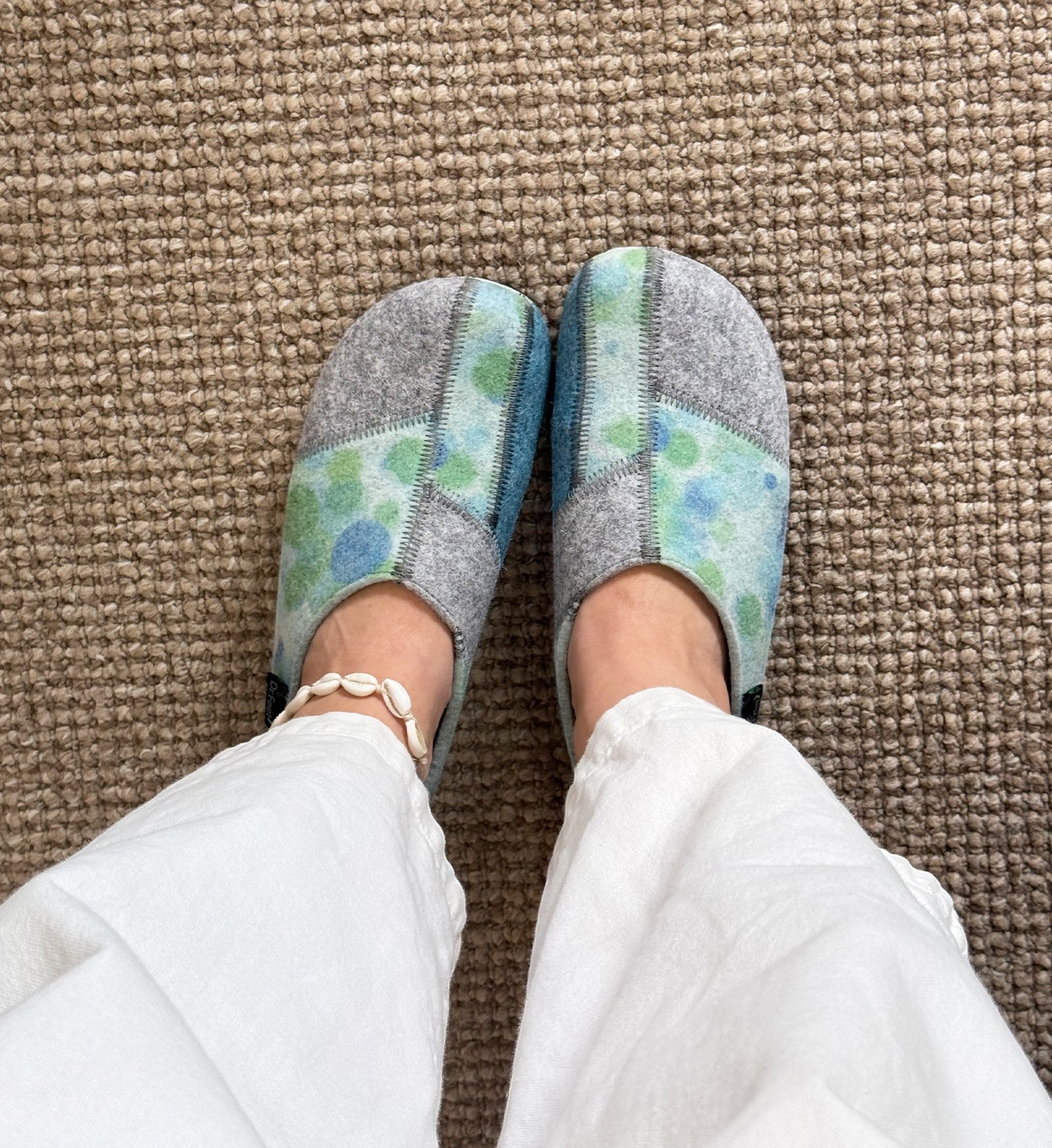 House of Florian DR. FEET Hilda wool felt slippers in blue bubbles pattern worn with white trousers on carpet