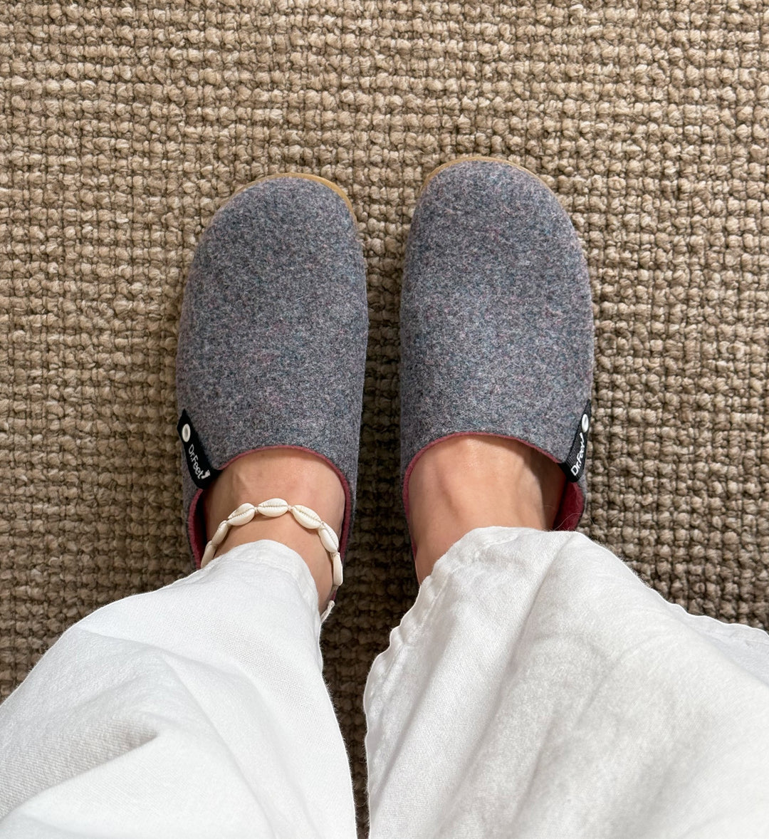 House of Florian Husky Heather grey felt slippers worn with white linen trousers and a shell anklet