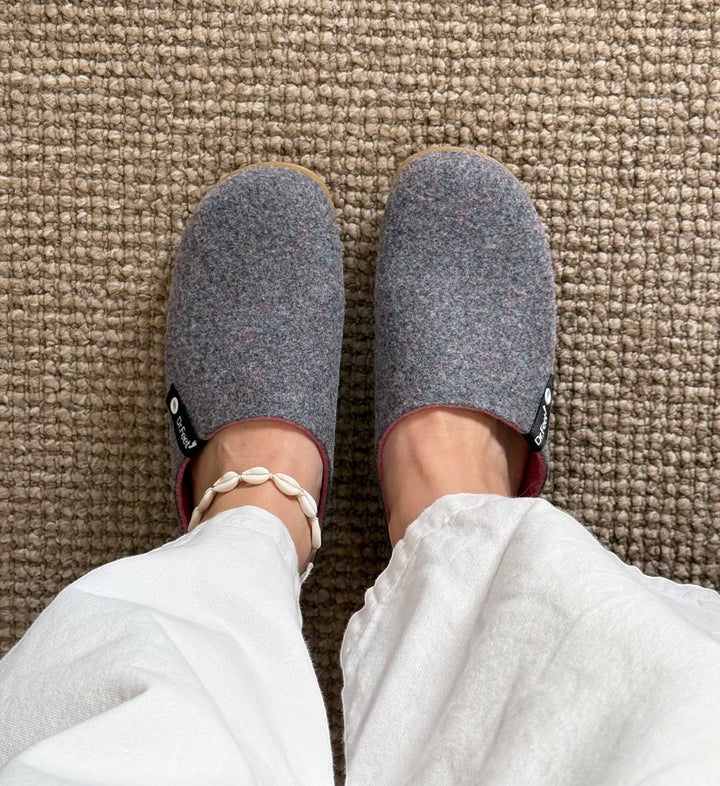 House of Florian Husky Heather grey felt slippers worn with white linen trousers and a shell anklet