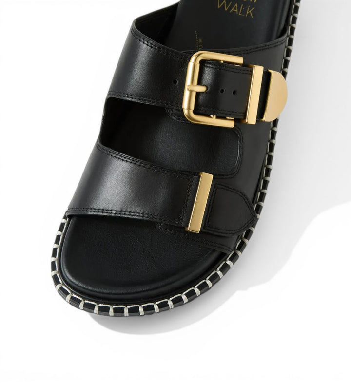 House of Florian Iyami W black leather double strap sandals with gold buckle detail and contrast stitching.