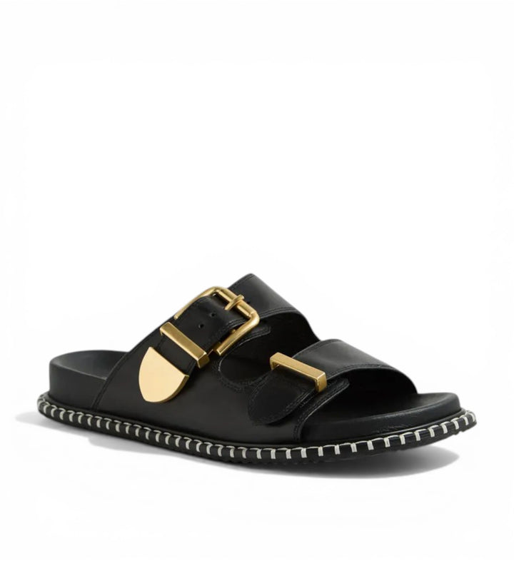 House of Florian Iyami W black leather slide sandals with double gold buckles and decorative stitching.