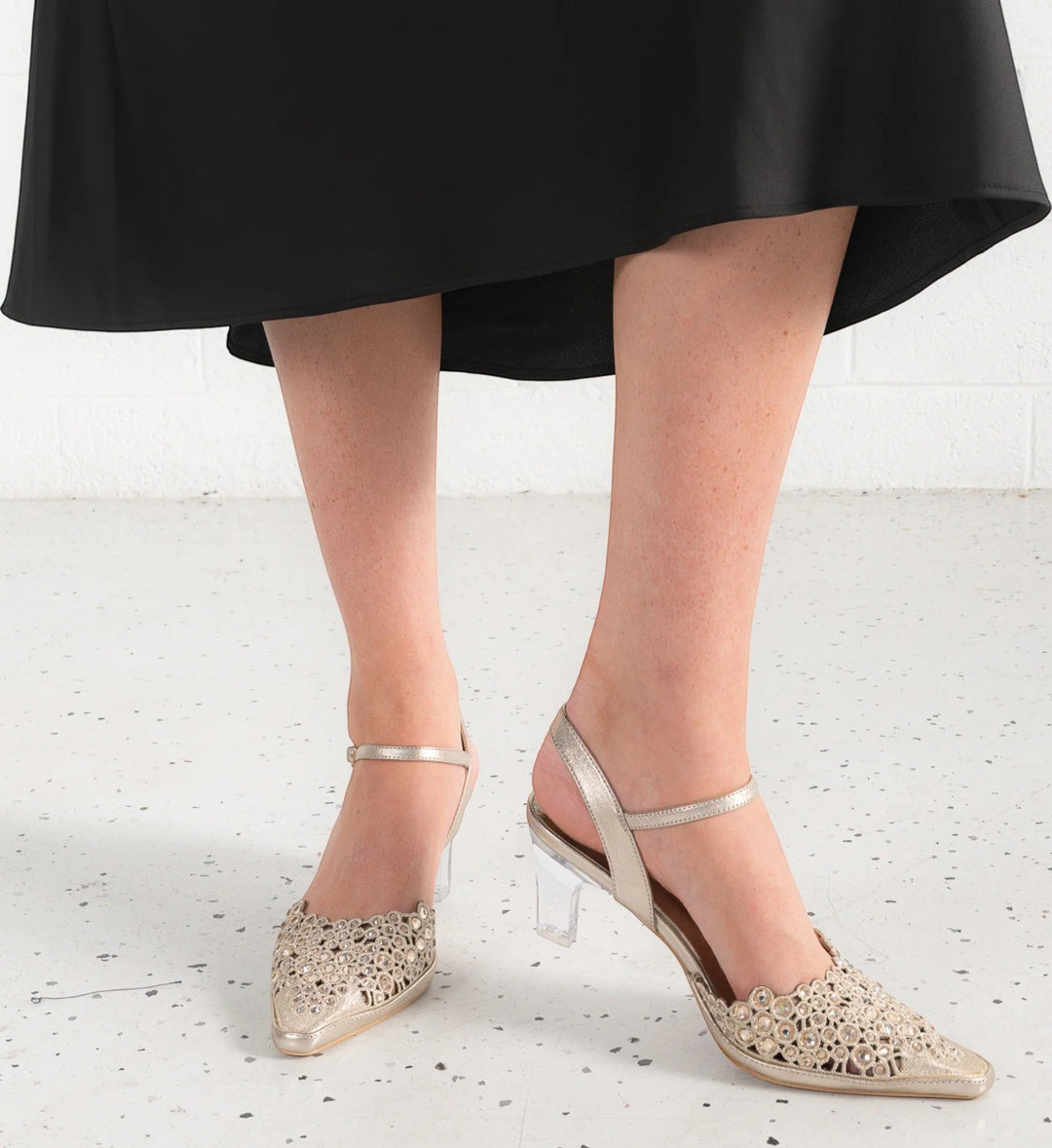 House of Florian Kyler Gold metallic pointed-toe slingback heels with intricate cut-out detail and clear block heel.