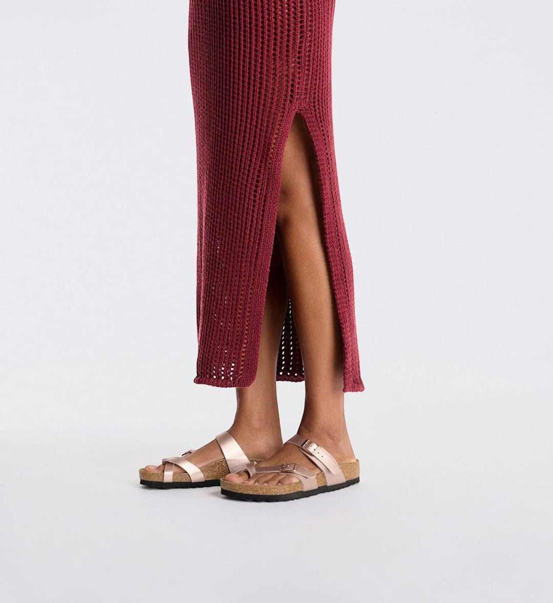 House of Florian Mayari copper Birko-Flor sandals with toe loop and adjustable buckles, worn with a maroon dress.