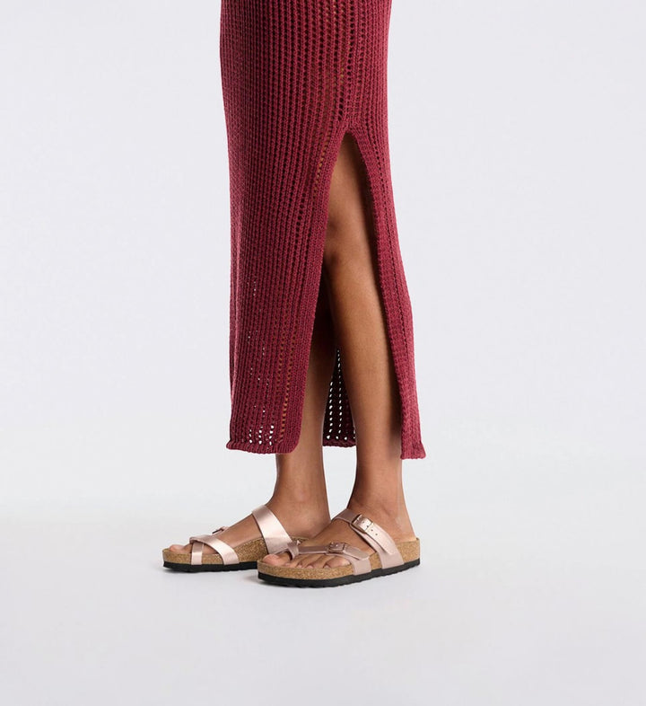 House of Florian Mayari copper Birko-Flor sandals with toe loop and adjustable buckles, worn with a maroon dress.