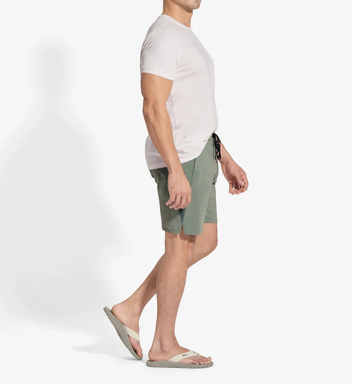 House of Florian Ohana Mens Tapa Clay shorts with a light pink t-shirt and flip-flops.