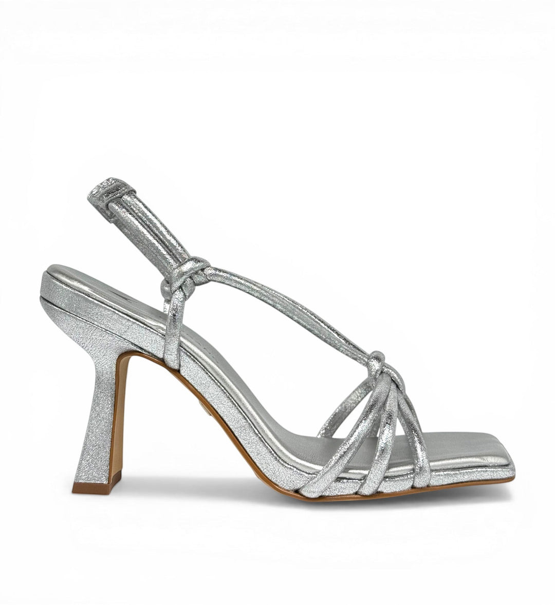 House of Florian silver metallic square-toe heeled sandals with knotted straps and a flared heel.