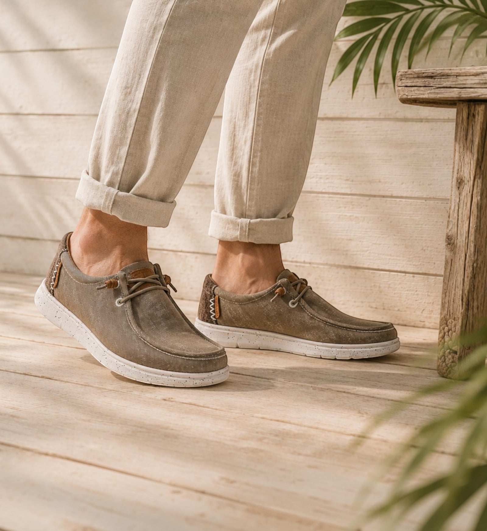 House of Florian Hipster Taupe casual slip-on shoes with white speckled soles worn on a wooden deck by the beach.