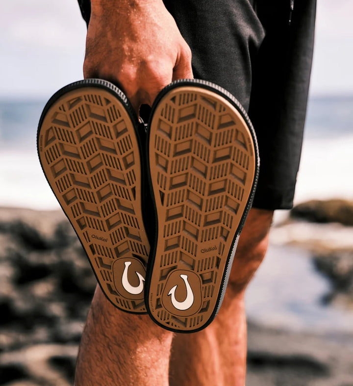 House of Florian Ulele Lanai Lava Rock flip-flops with brown patterned soles and white fishhook logo.